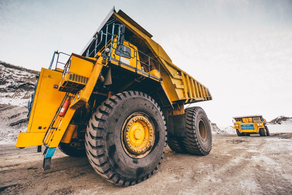 A Large Yellow Dump Truck Is Parked In A Dirt Field — Skilled Transport Training And Assessment in Woongarrah, NSW
