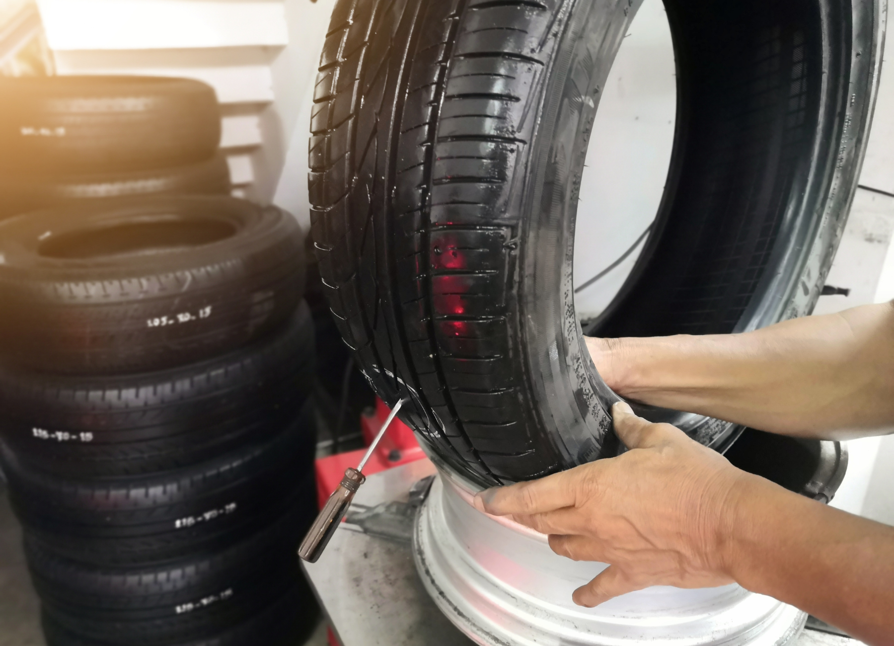 a person is fixing a tire with a screwdriver