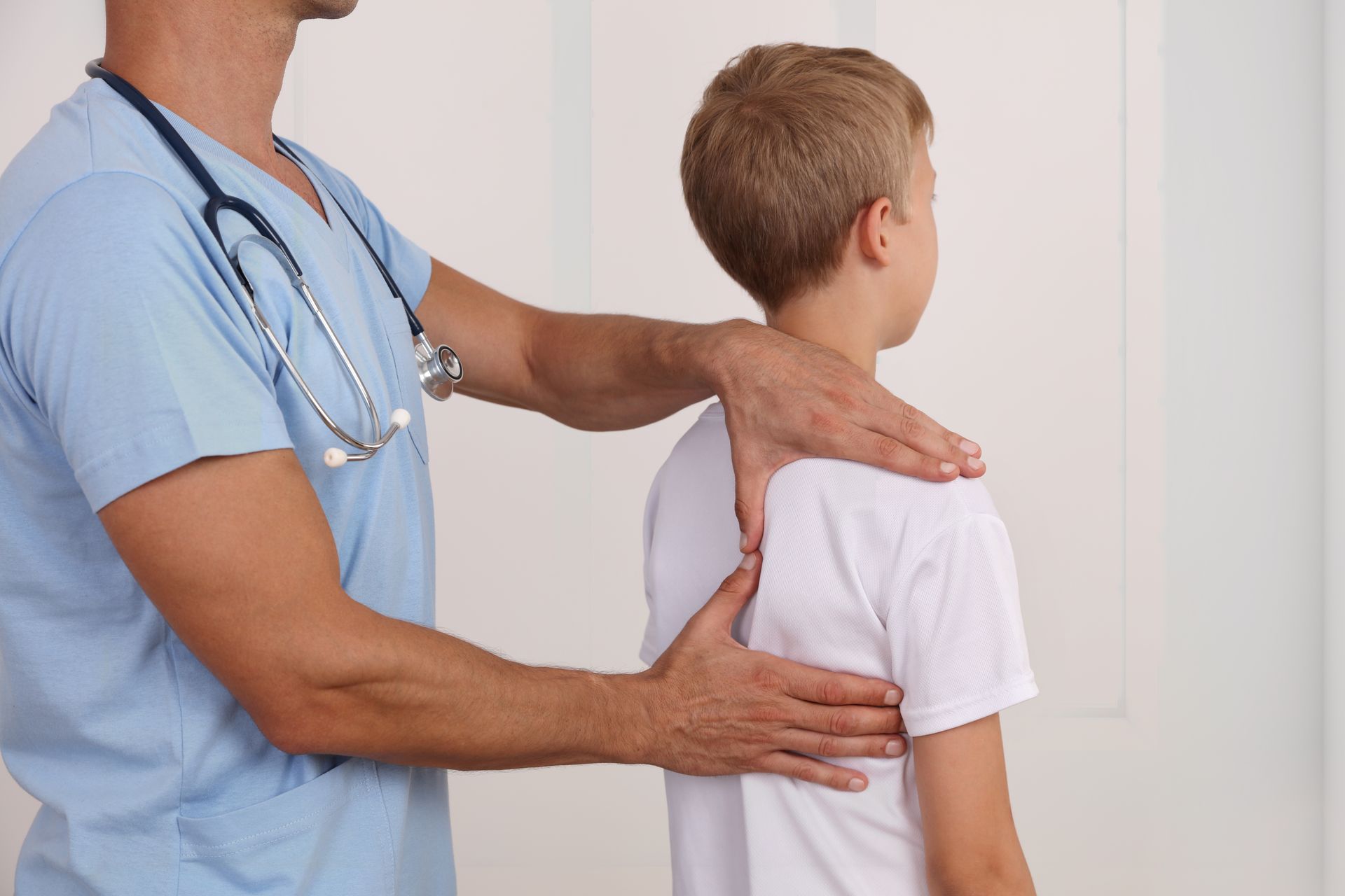 Doctor examining a boy’s back during a medical checkup