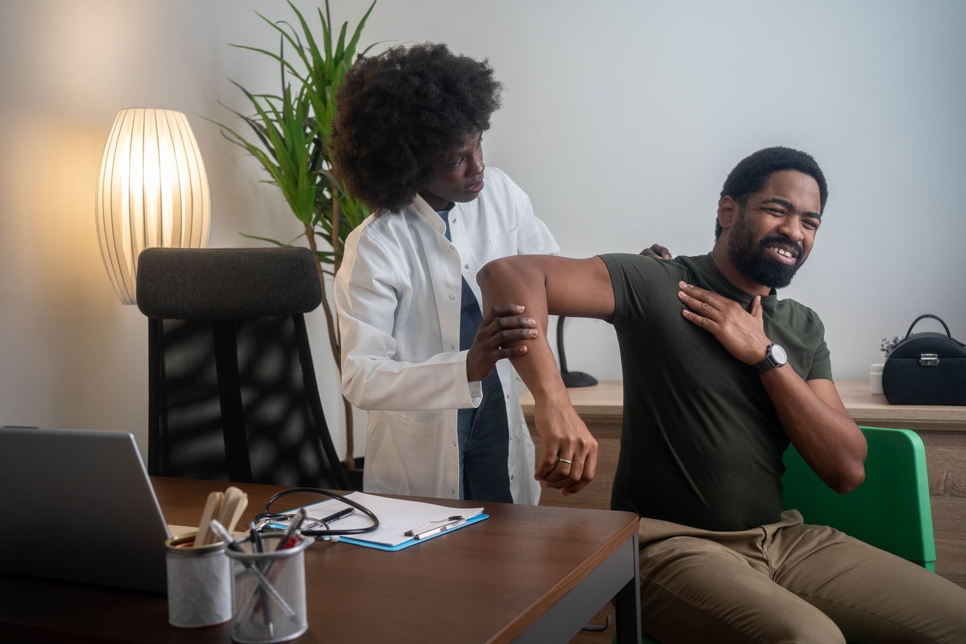 Physical therapist helping seated patient stretch in an office setting