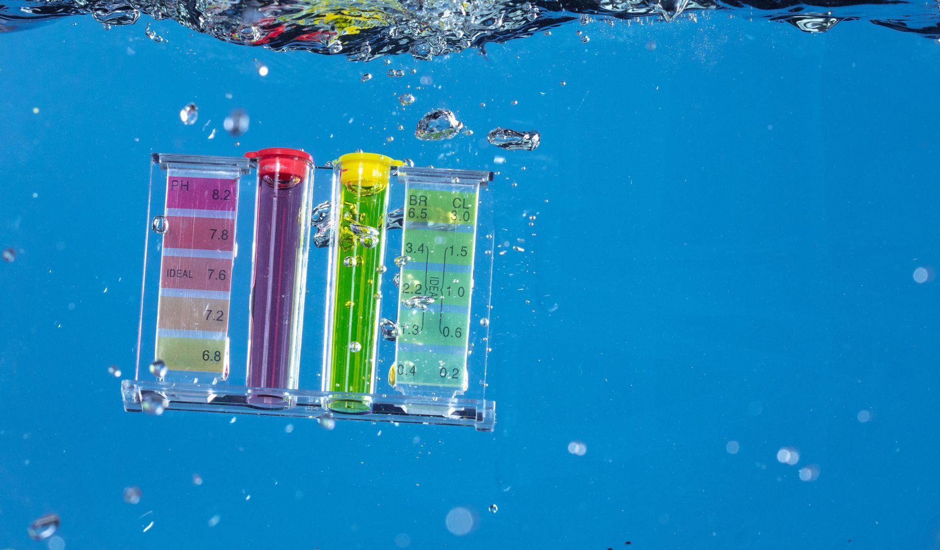 Teststreifen, die in blaues Wasser getaucht werden, zeigen unterschiedliche Farbergebnisse.