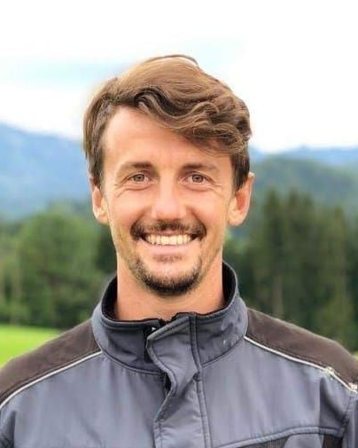 Taucher in schwarzem Neoprenanzug, untergetaucht in trübem Wasser in der Nähe eines Docks, benutzt Ausrüstung.