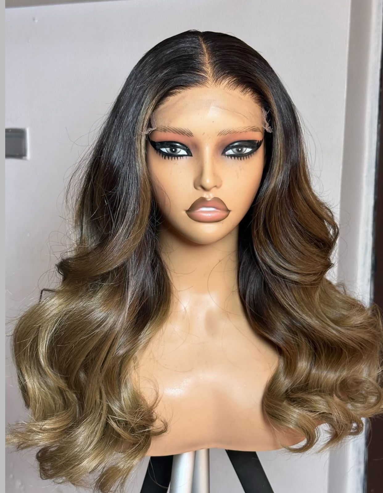 Peluca ombré marrón y rubia colocada sobre una cabeza de maniquí.