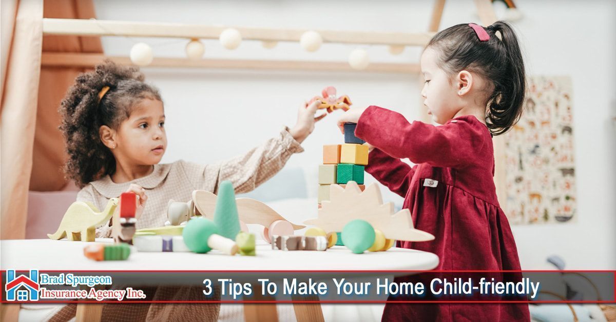 Two children playing with colorful wooden building blocks on a table in a brightly lit room.
