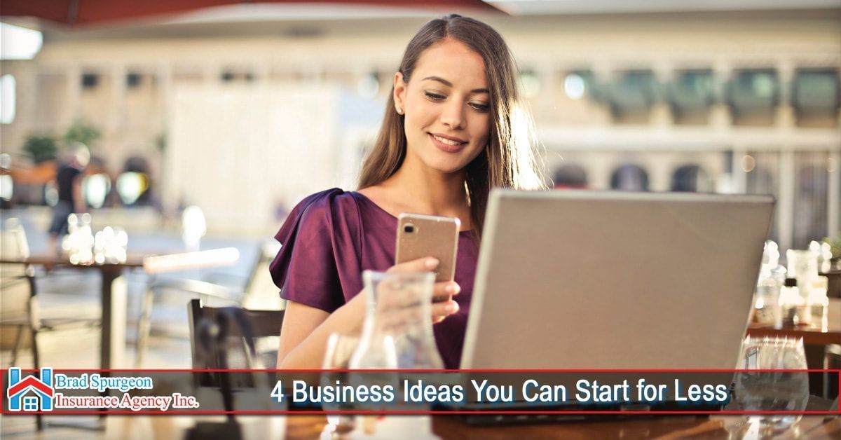A woman in a purple top looks at a laptop and smartphone while sitting at a restaurant table