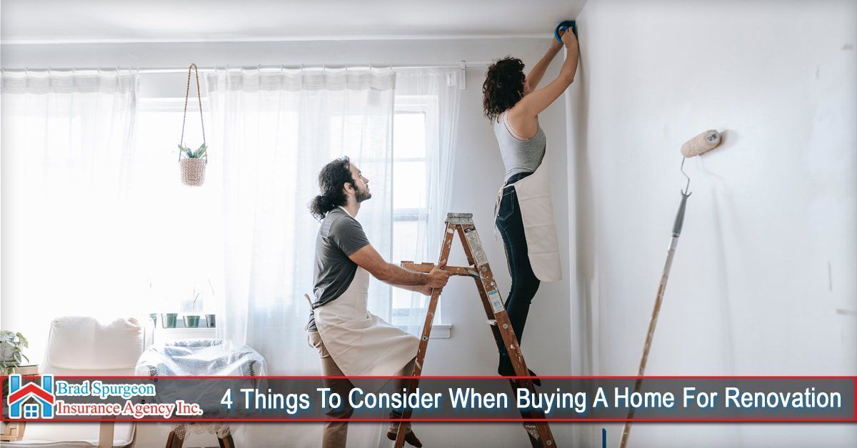 Two people painting a room, one standing on a ladder reaching for the ceiling corner, with painting tools nearby.