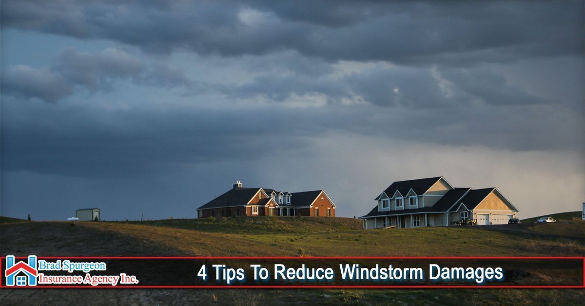 Two houses sit on a grassy hill under a dramatic, dark storm sky