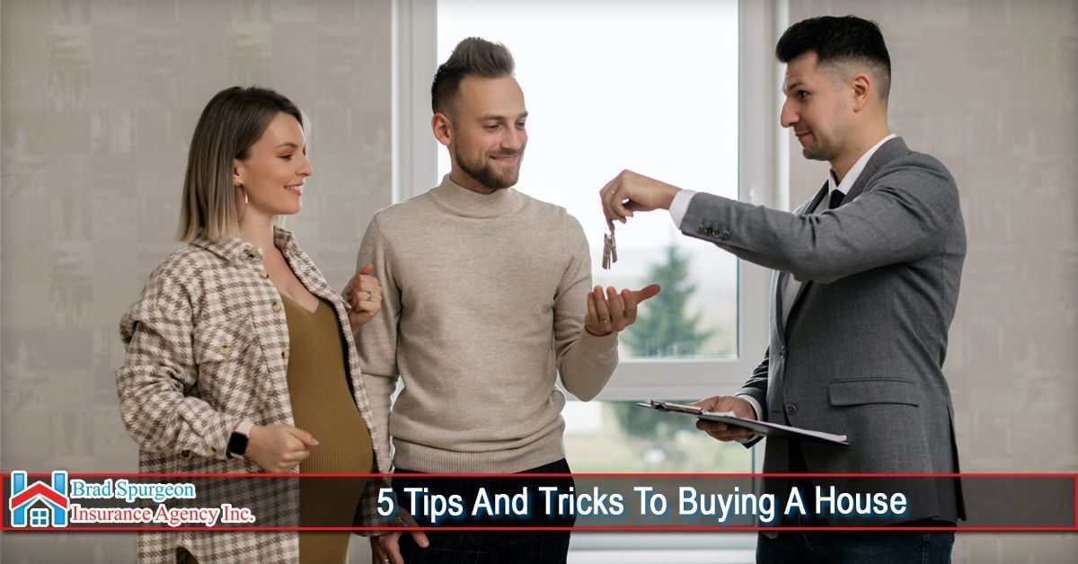 A real estate agent hands keys to a couple in an empty room