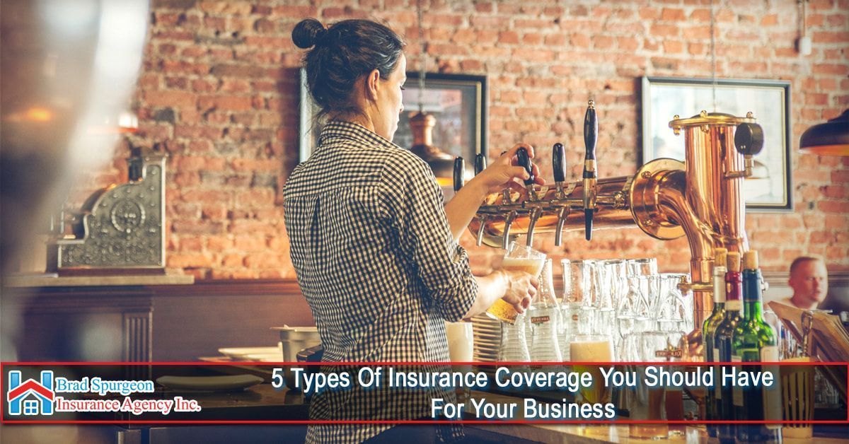 A person pours a beverage at a bar with exposed brick walls