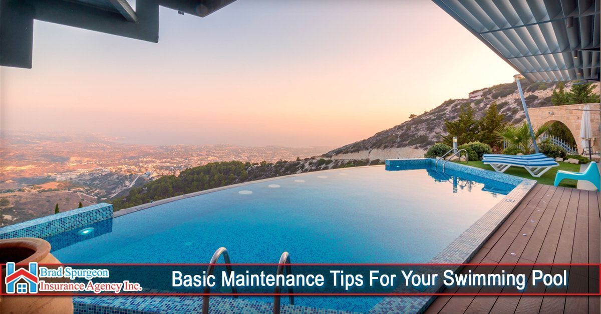 An infinity pool overlooking a sunset city view with a wooden deck and pool chairs