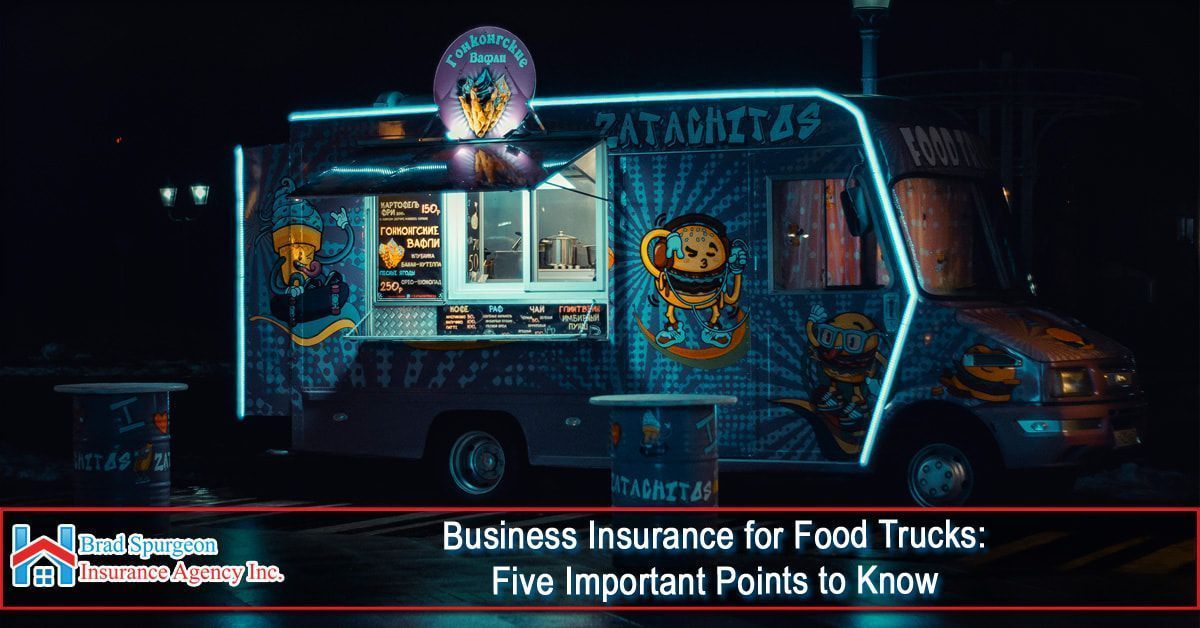 A brightly lit, blue-decorated food truck at night