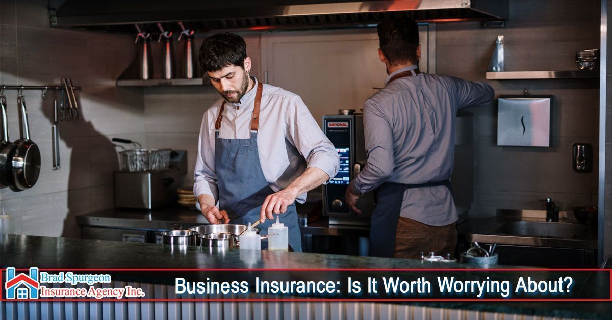 Two people working in a restaurant kitchen behind a counter