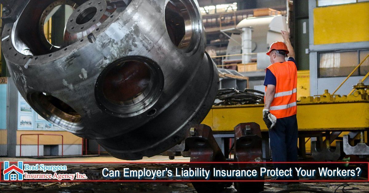 A worker in an orange safety vest guides a heavy industrial component suspended by a crane in a factory setting.