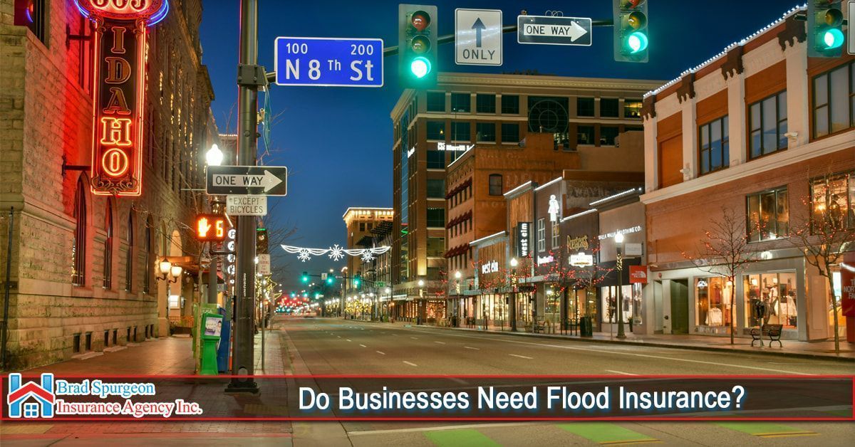 A twilight view of a downtown city street with retail buildings and a blue N 8th St sign. 