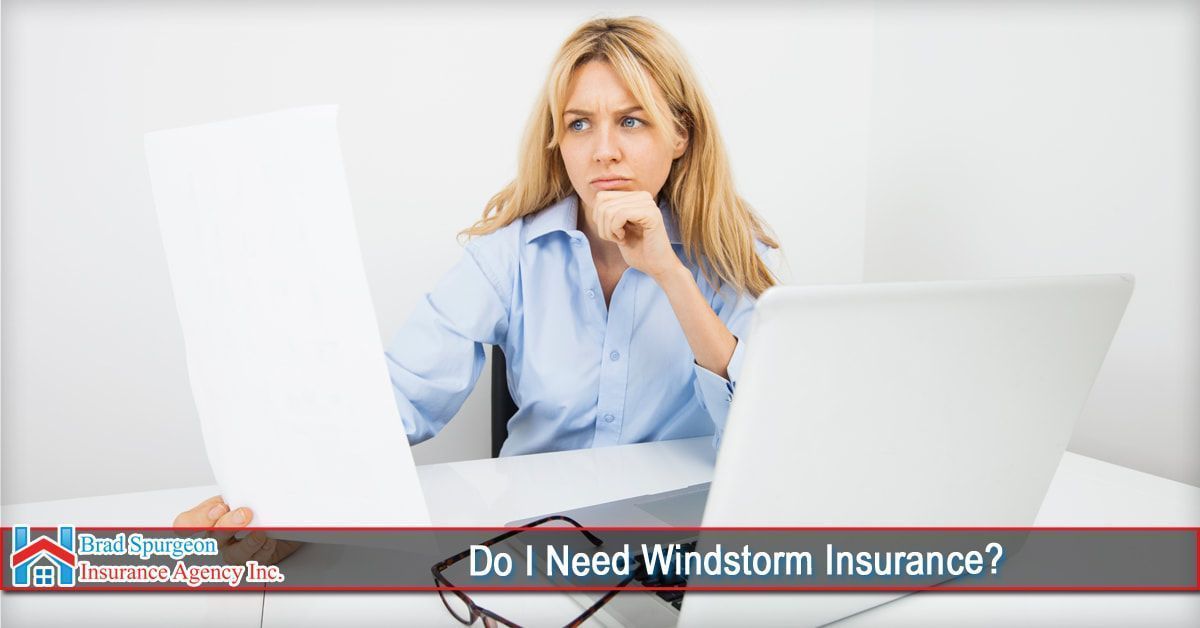 A person sits at a desk with a laptop, looking concerned while holding a document. 