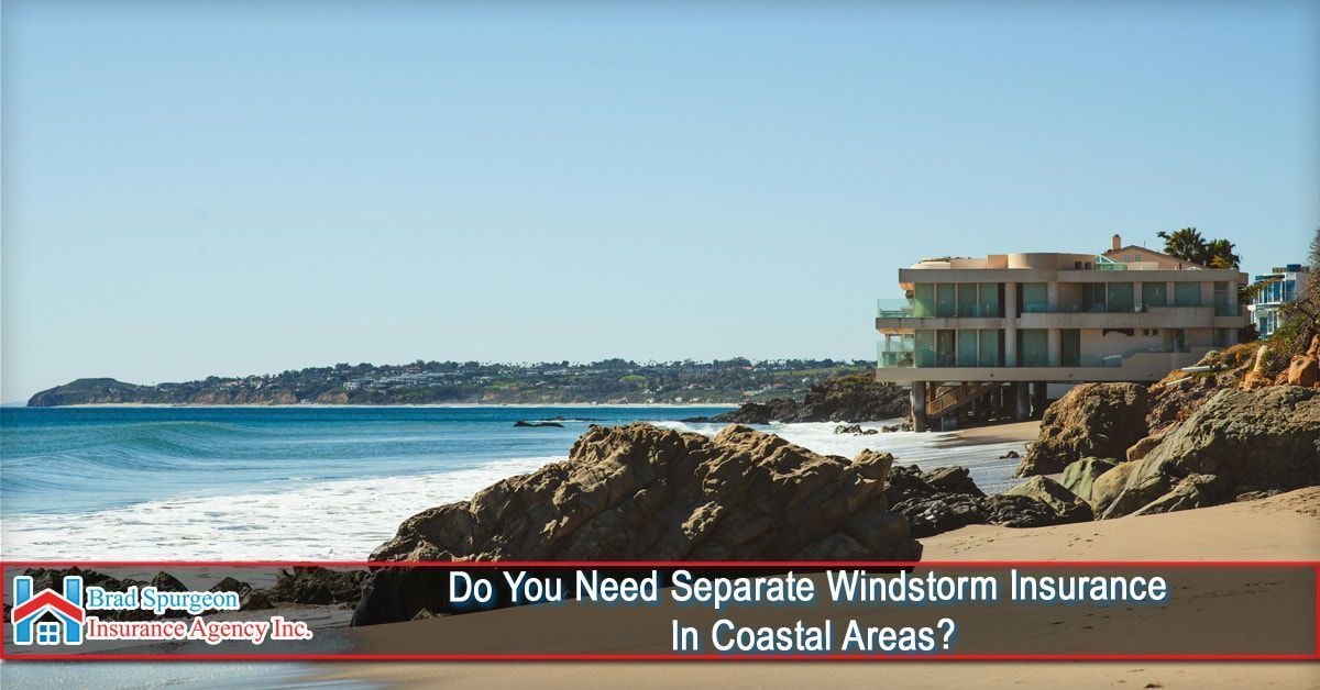 A luxury house on a rocky, sandy beach coastline under a clear blue sky