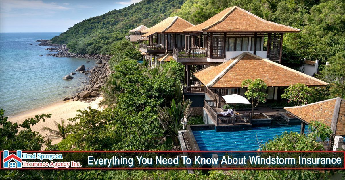 A luxury resort with tiled-roof villas and a pool on a tropical hillside overlooking a beach