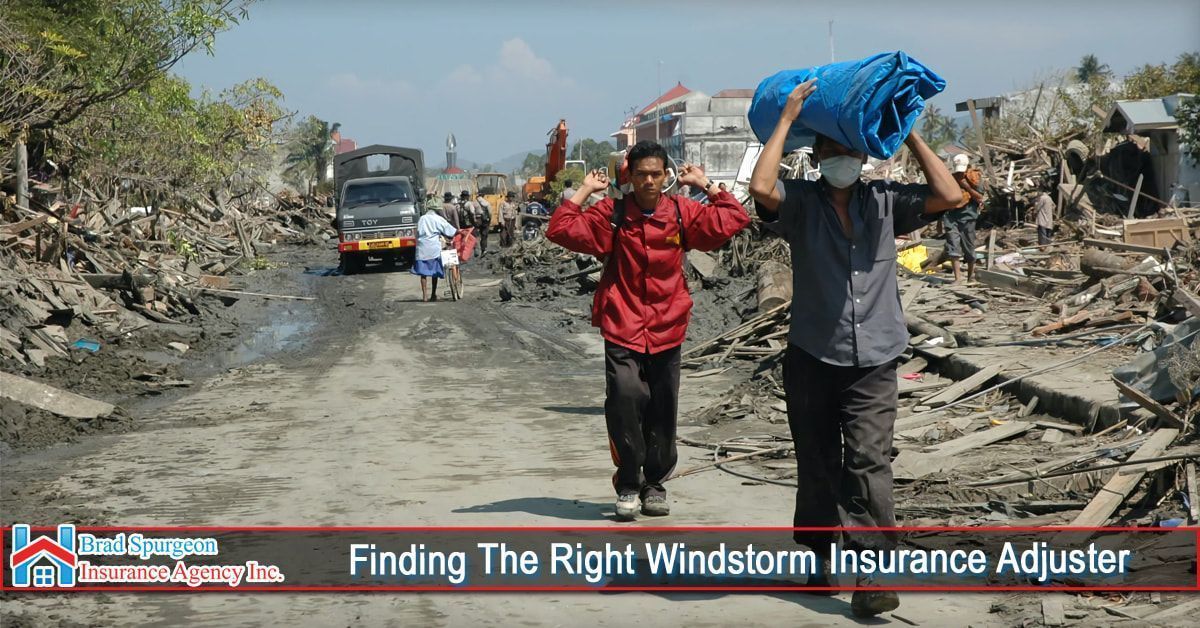 Two people walk down a debris-filled, muddy road past destroyed buildings
