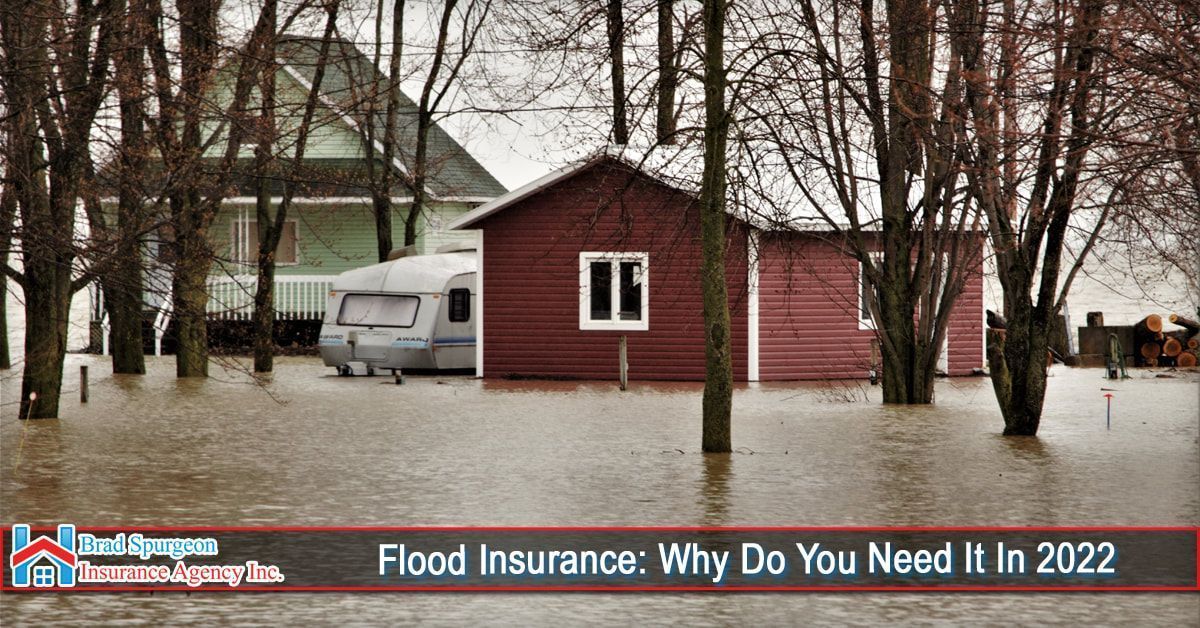 A flooded yard surrounding a house and a camper