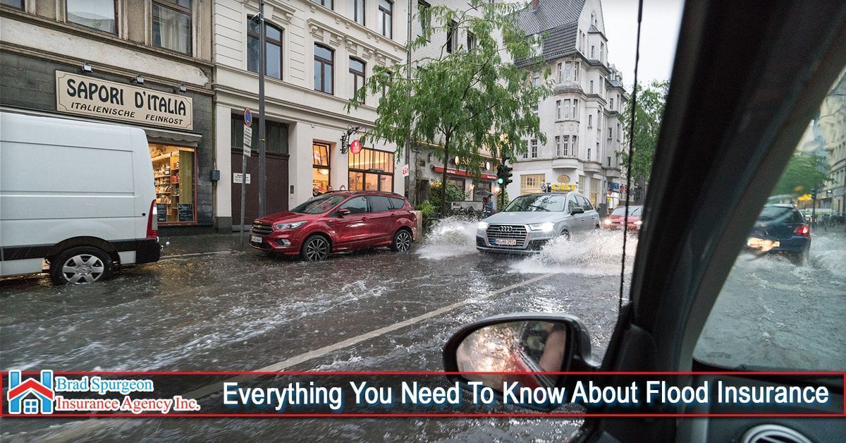 Vehicles driving through a flooded city street on a rainy day