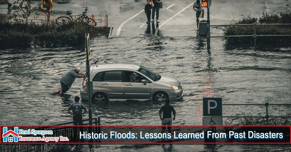 A person pushes a silver car through a flooded street with a parking sign nearby, under a text overlay about historic floods.