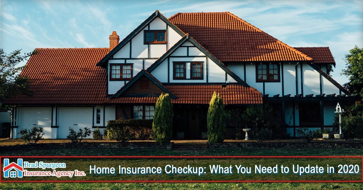 A two-story Tudor-style home with a red tile roof
