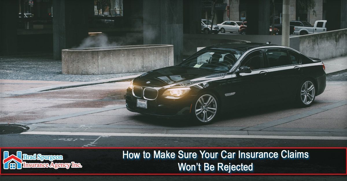 A black BMW drives on a city street 