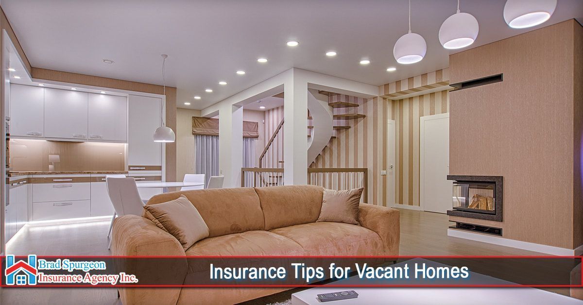 A modern, well-lit living room with a beige sofa, white kitchen, and a fireplace