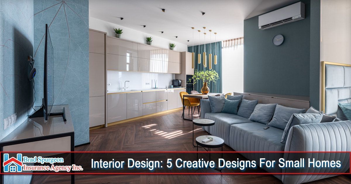 A modern, open-concept apartment interior with blue walls, a gray sofa, light kitchen cabinetry, and dining area.