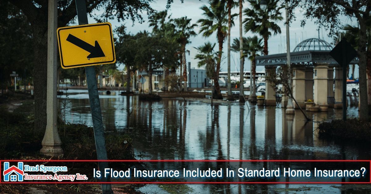 A flooded street with palm trees and a road sign