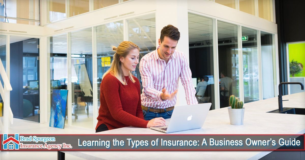 Two professionals in a modern office looking at a laptop