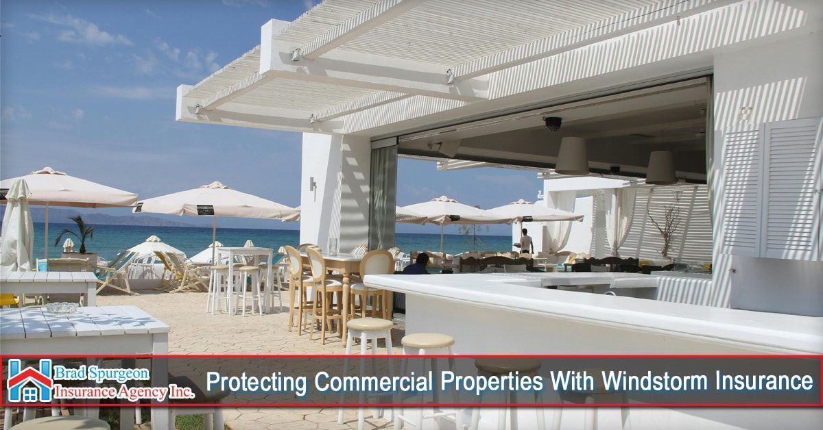 A beachfront restaurant with white furniture and umbrellas