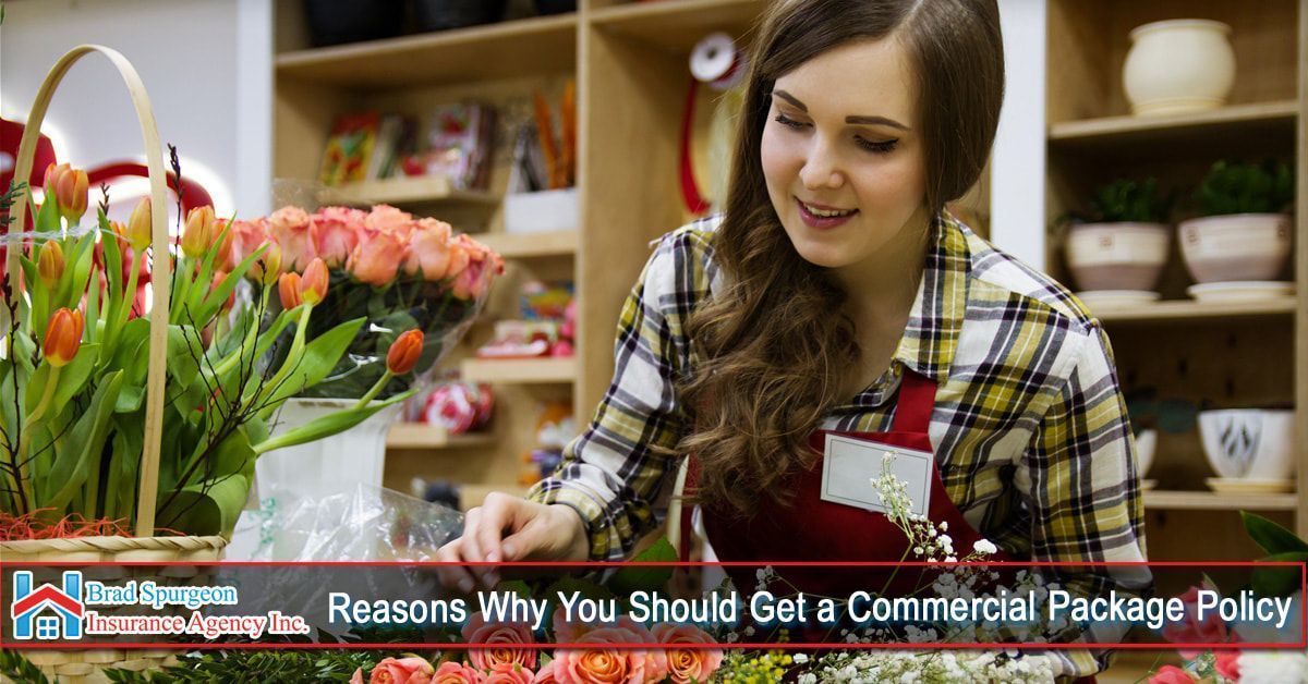 A florist works with flowers in a shop with shelves
