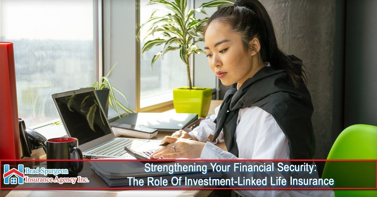 A person works at a desk with a laptop and documents near a window