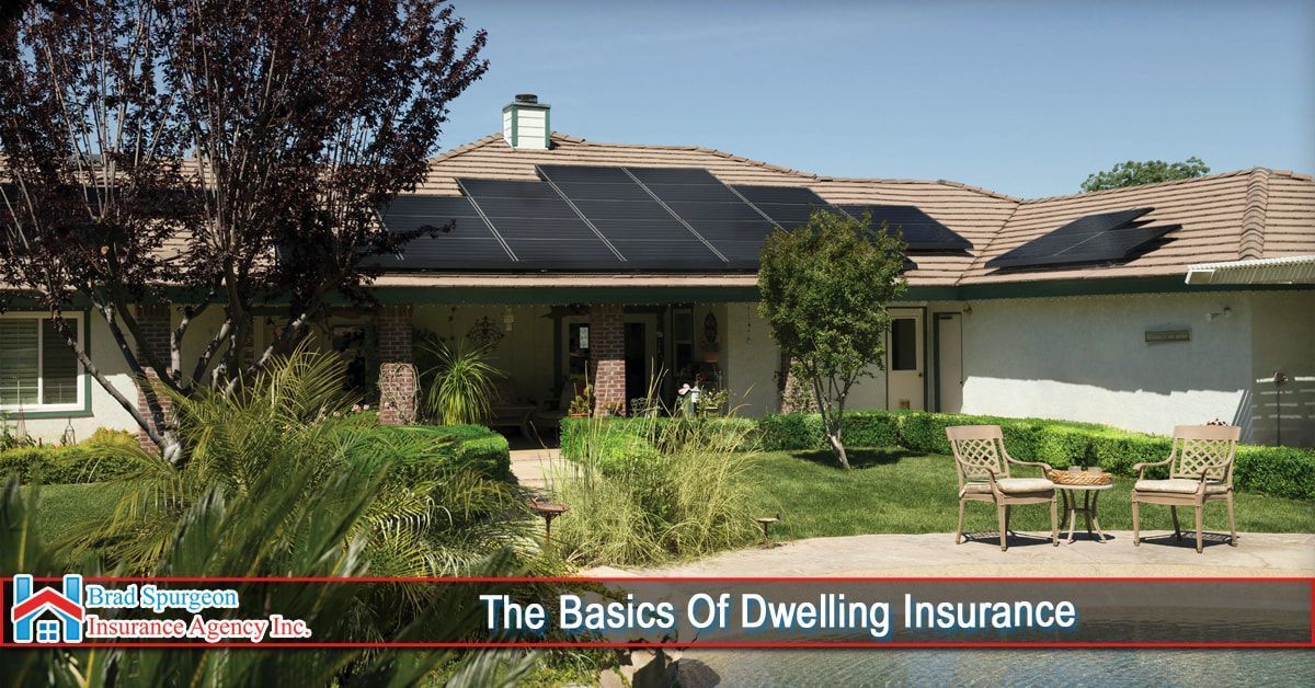 A house with solar panels on the roof and a patio with chairs