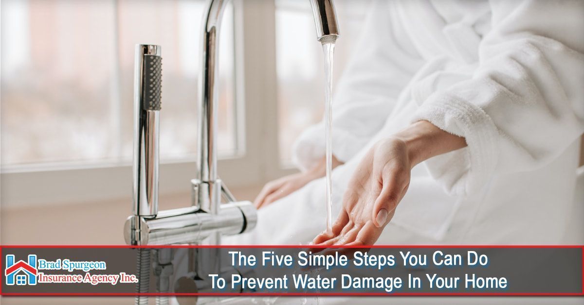A person in a bathrobe reaches hands under a bathroom faucet