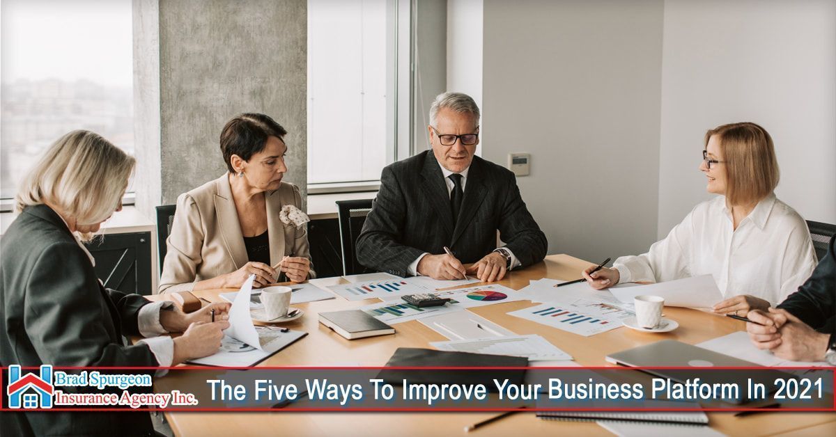 Four professionals sit around a conference table reviewing documents