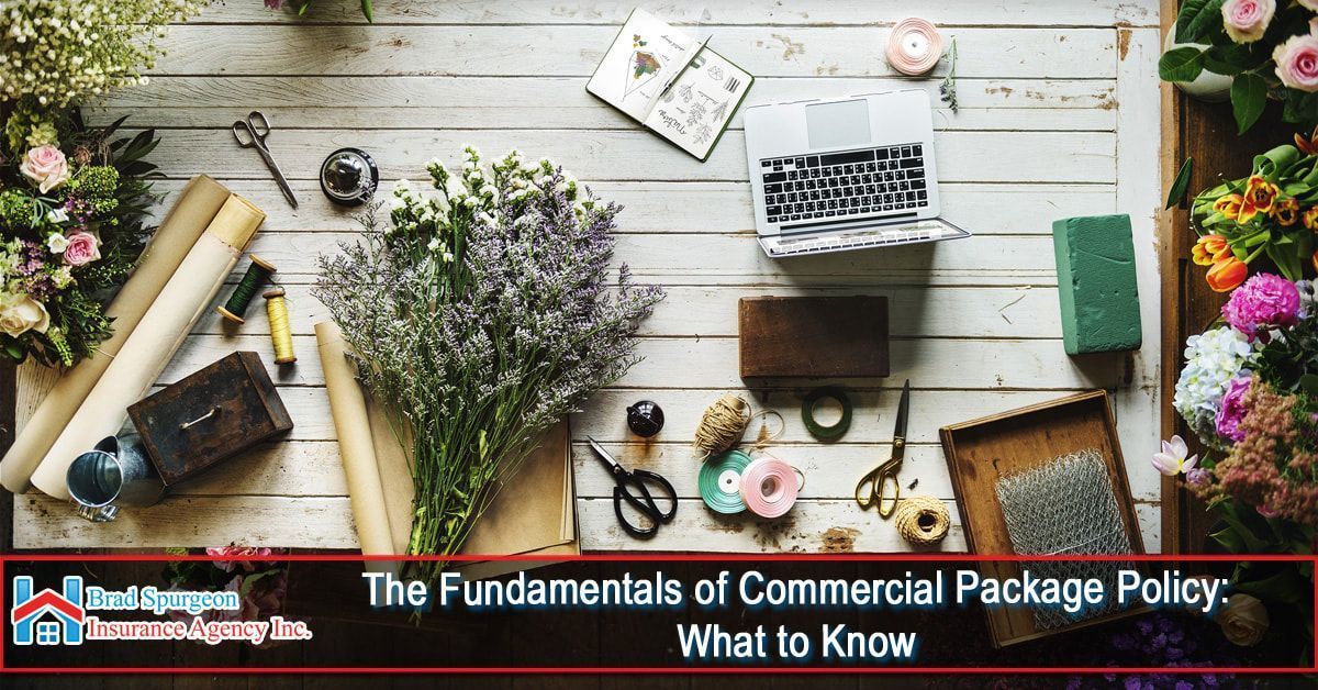 Top-down view of florist tools and flowers on a white wooden table 