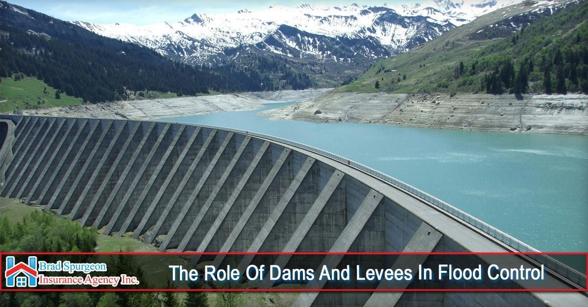 A concrete dam holds back a blue reservoir in a mountain valley
