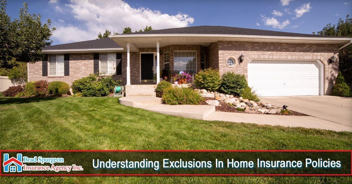 A suburban brick house with a white garage and a green lawn under a blue sky