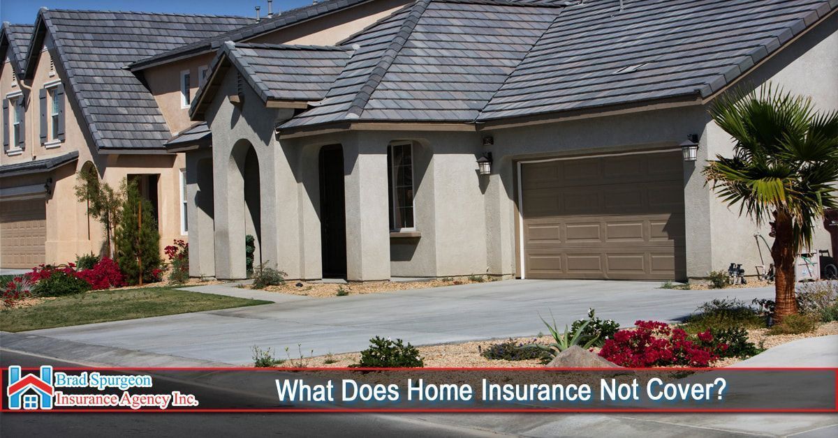 A suburban house with a gray roof and tan stucco exterior