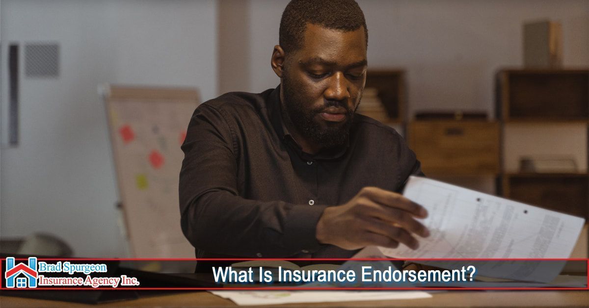 A person in a dark shirt reviews documents at a desk in an office