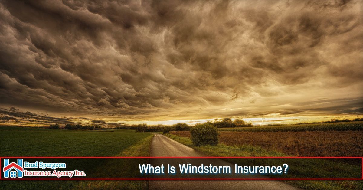 A road leads toward a horizon under a vast, dark, turbulent storm sky