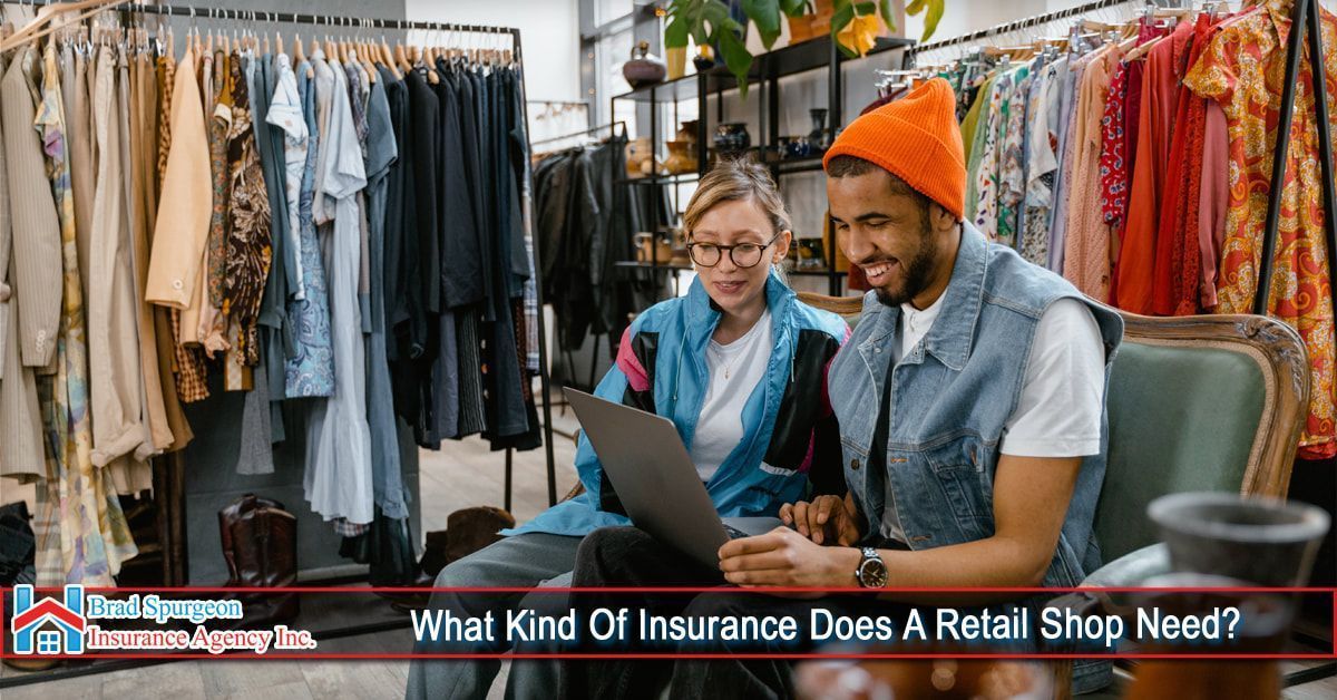 Two people work on a laptop inside a clothing store