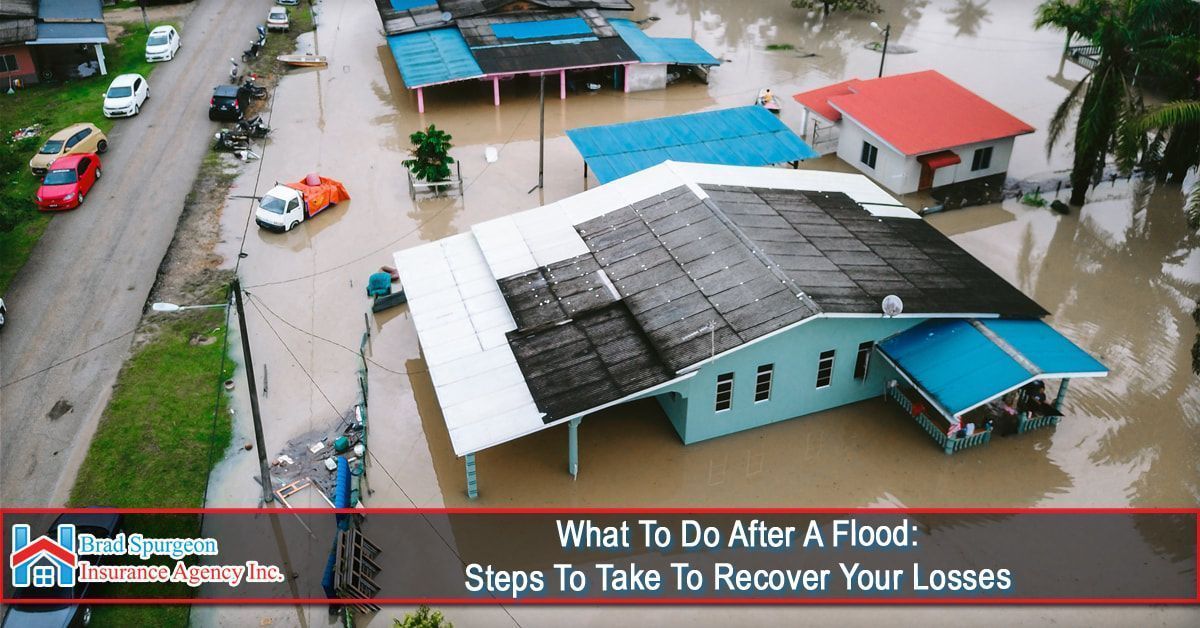 An aerial view of a flooded neighborhood featuring houses surrounded by murky water