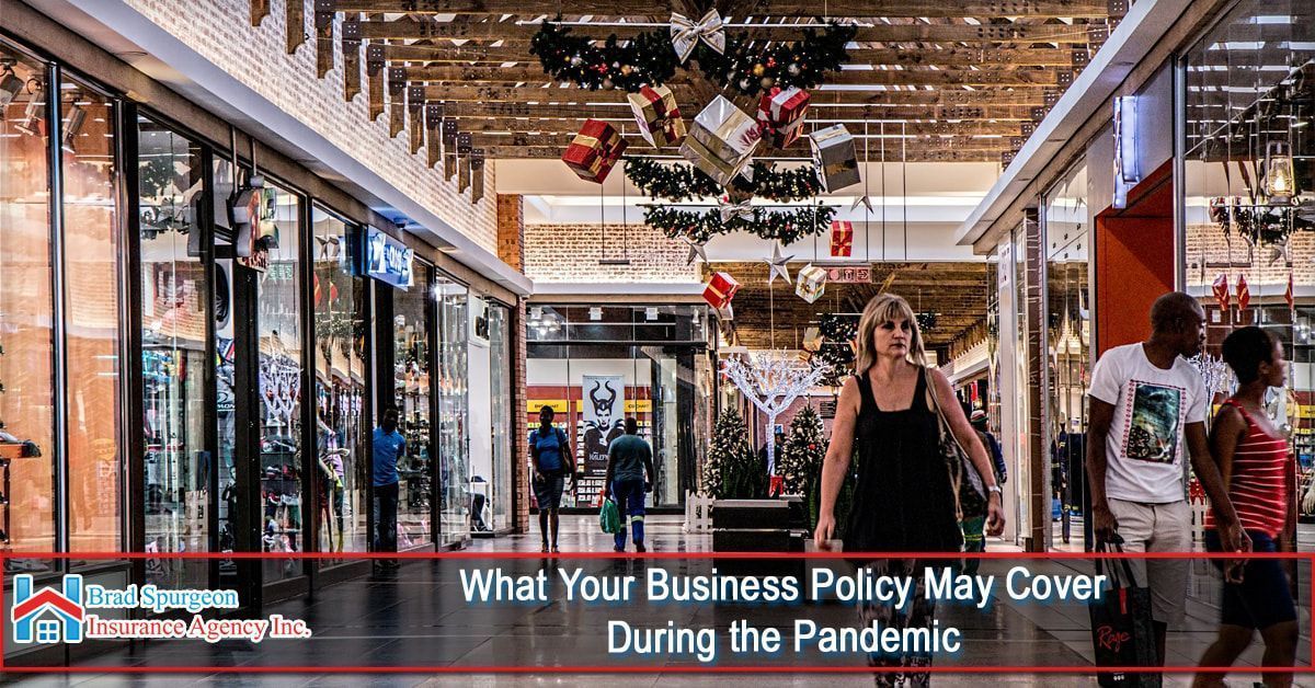 People walk through an indoor shopping center decorated for the holidays