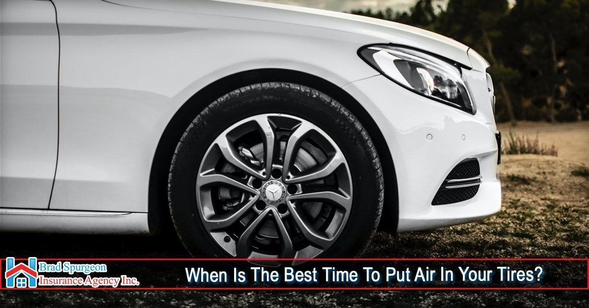 Close-up of a white car tire parked on gravel