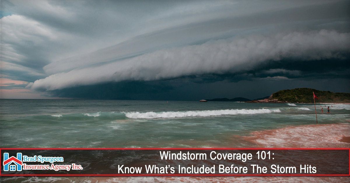 A large, dark storm shelf cloud looms over a coastal beach