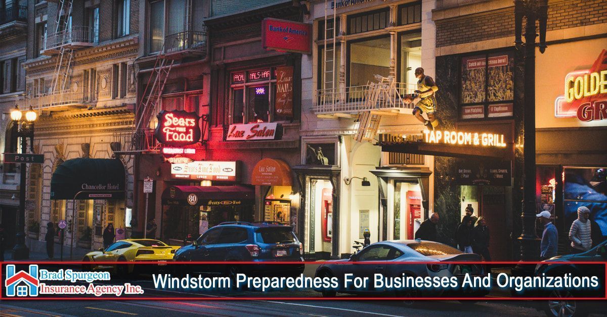 Nighttime city street with businesses, cars