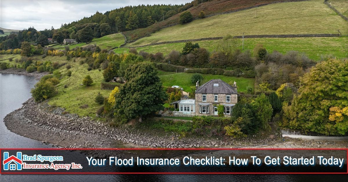 An aerial view of a house by a lake with green hills